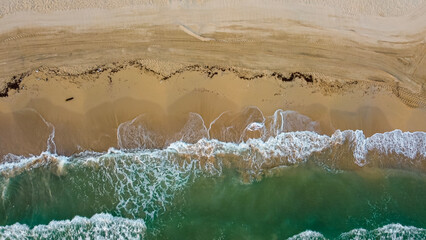 Top down view beach and mediterranean sea with waves. Aerial view abstract coastline in summer....