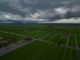 The famous water canals of the Netherlands seen from above at dusk. Vast green plain crossed by a river in the Dutch countryside 