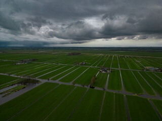 The famous water canals of the Netherlands seen from above at dusk. Vast green plain crossed by a river in the Dutch countryside 
