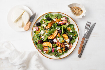 Grilled pear, toasted bacon, blackberries and nuts in a delicious baby spinach salad