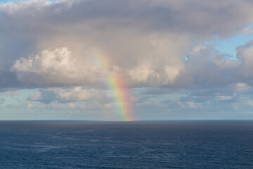 Arcobaleno sul mare con nuvole