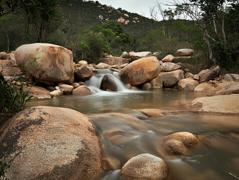 Serene mountain stream flowing over smooth rocks