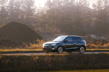 Small hatchback navigating country road view