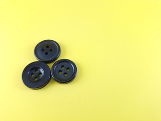 Three black buttons on a yellow background.
