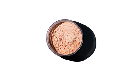  A round, open makeup container filled with loose powder foundation, set against a bright white background, casting a soft shadow.