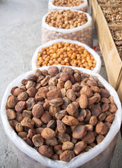 Bukhara, Uzbekistan - October 15, 2024: Sacks filled with dried apricots and other nuts are neatly arranged on a street at a local market