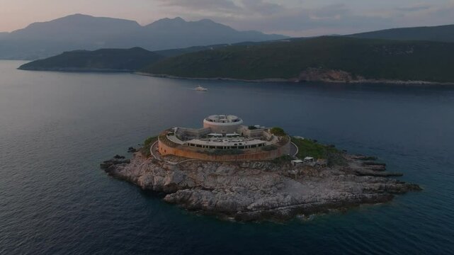 Cinematic view around Mamula Island with a hotel with pools, the former prison, in the Adriatic Sea at Lustica Bay during sunset, Montenegro, Europe