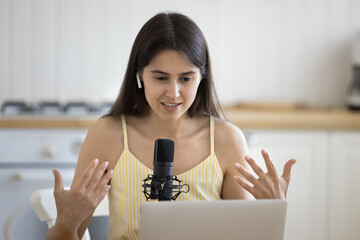 Home studio. Smart generation z woman wear in-ear wireless earbuds record podcast create audio...