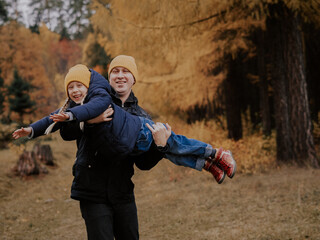 Fototapeta premium Dad-daughter. Dad and daughter walking in the forest in the fall. Family on a walk