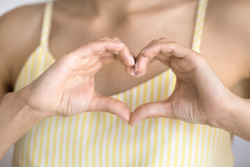 Sincere feelings. Close up cropped shot young lady holding hands at chest join fingers into tender hear shape. Gratitude thank you donation charity love confession Valentine day cardio checkup concept