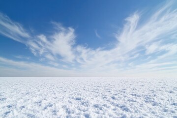 A snowy field with a blue sky in the background, perfect for winter or landscape scenes