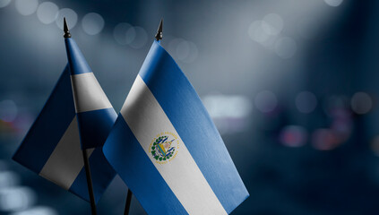 Small flags of the Salvador on an abstract blurry background