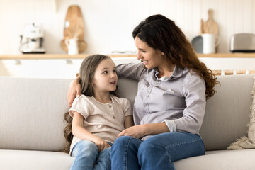 Talking to mom. Attentive caring foster mother spend quality time with beloved little daughter hug...