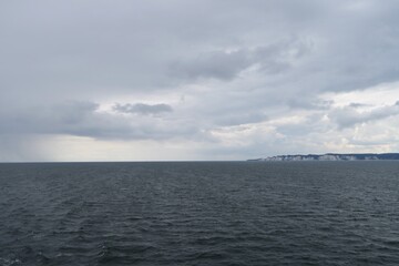 Obraz premium Von der Fähre zwischen Travemünde und Trelleborg ist die Kreideküste der dänischen Insel Mön an einem wolkigen Sommertag zu sehen.