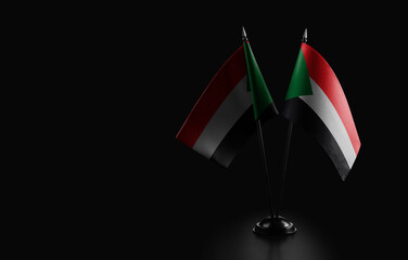 Small national flags of the Sudan on a black background