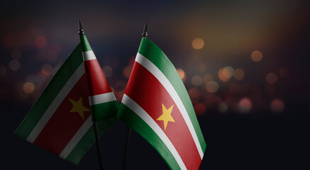 Small flags of the Suriname on an abstract blurry background