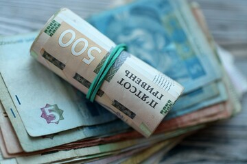 Big amount of different ukrainian hryvnia currency money bills on wooden background