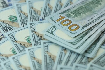 Many hundred dollar bills new banknotes in big pile under the natural light