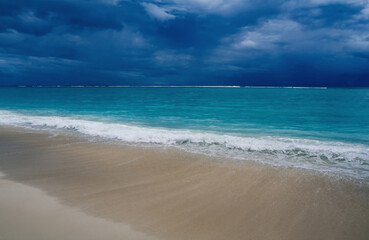 Fototapeta premium Tropical beach of Indian Ocean, dramatic sky over turquoise lagoon. Storm approach. Beautiful seascape. Mauritius island.