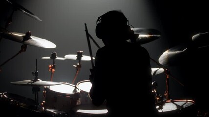 Skilled drummer punching hi-hats, playing music in rock gig, rearview in dark. Hobby and passion, young adult man rehearsing to beat rhythm, enjoy modern music, cool guy rocking crowd in concert hall