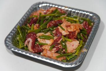 容器に入った牛バラ肉とニンニクの芽