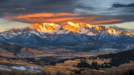 Obraz premium Snow-covered mountains at sunrise with golden light, ideal for nature and outdoor themes