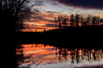 Sonnenuntergang &uuml;ber einem kleinen See im Wald