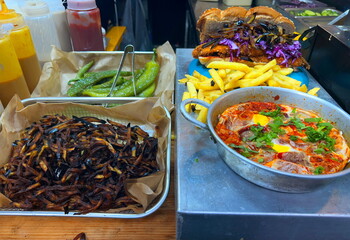 Shakshuka is a Middle Eastern dish made with eggs and tomatoes. Hot peppers, French fries and a challah sandwich with schnitzel and eggplant. Street food at a Tel Aviv market