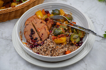 Vegan seitan ham roast, festive meatless dish, along with roasted vegetables