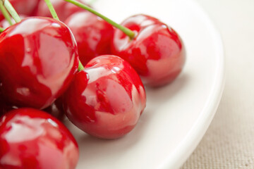 Fresh red cherries on a white plate
