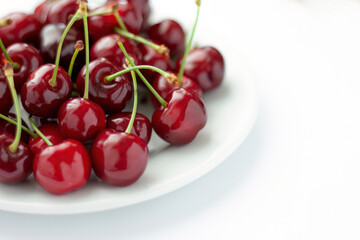 Pile of fresh cherries on a white plate
