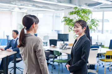 先輩社員にオフィスを案内してもらうフレッシュな女性
