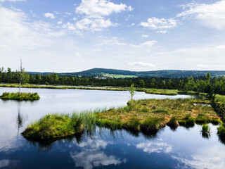 A lake in a national park reflecting a blue sky with clouds.
