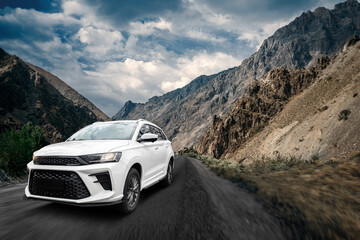 A white car is driving down a mountain road