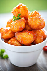 Fried potato balls in white bowl on wooden table. Possible use Food photography