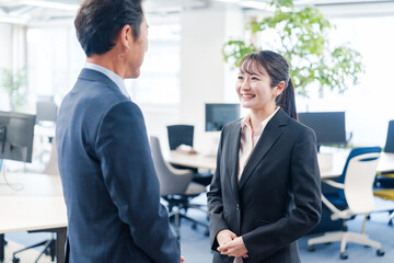 笑顔で上司と話をする若いビジネスウーマン