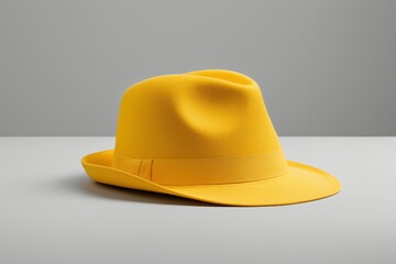 Fototapeta premium yellow hat on a table with a gray background