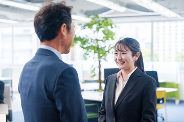 笑顔で上司と話をする若いビジネスウーマン