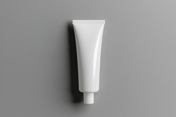 Minimalist matte gray squeeze tube mockup with angled tip on warm gray background for packaging design