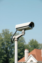 CCTV Camera Mounted on a Pole with a Residential House in the Background