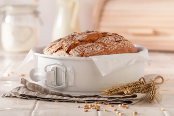 Healthy round loaf bread baked in a rustic bright kitchen.