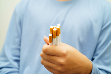 Asian man holding cigarette, no smoking.