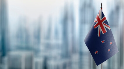 Small flags of the New Zealand on an abstract blurry background