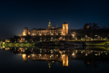 Poland, Krakow: Royal Castle of Wawel by night with reflection in Vistula River