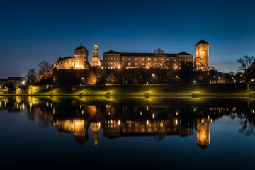 Poland, Krakow: Royal Castle of Wawel by morning blue hour with reflection in water