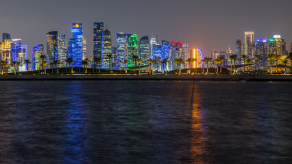 Doha city business downtown center panorama illuminated at night, with modern skyscrapers,...