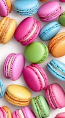 Assortment of colorful pastel macarons scattered on a white background. Sweet treats, French pastries, confectionery, delicious dessert