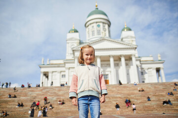 Adorable preschooler girl near Helsinki Cathedral (Helsingin tuomiokirkko) on Senaatintori in...