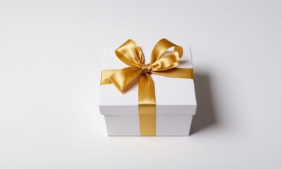 Obraz premium A stylish white gift box adorned with a gold satin ribbon, perfect for any special occasion.