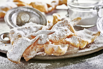 Polskie faworki (Skrzydła anielskie) z cukrem pudrem, podawane w przytulnej kuchni